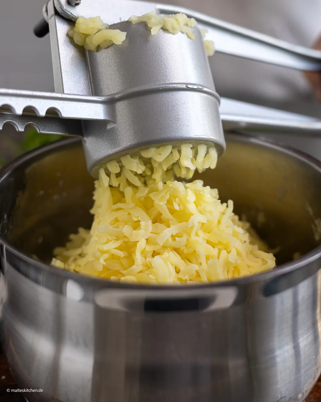 Presser les pommes de terre dans le presse-pommes de terre