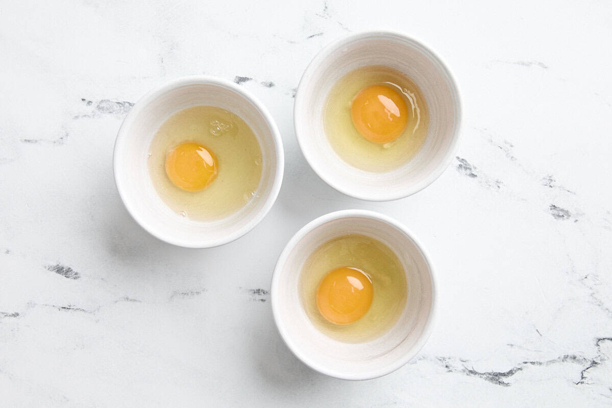 Œufs cassés dans des ramequins.