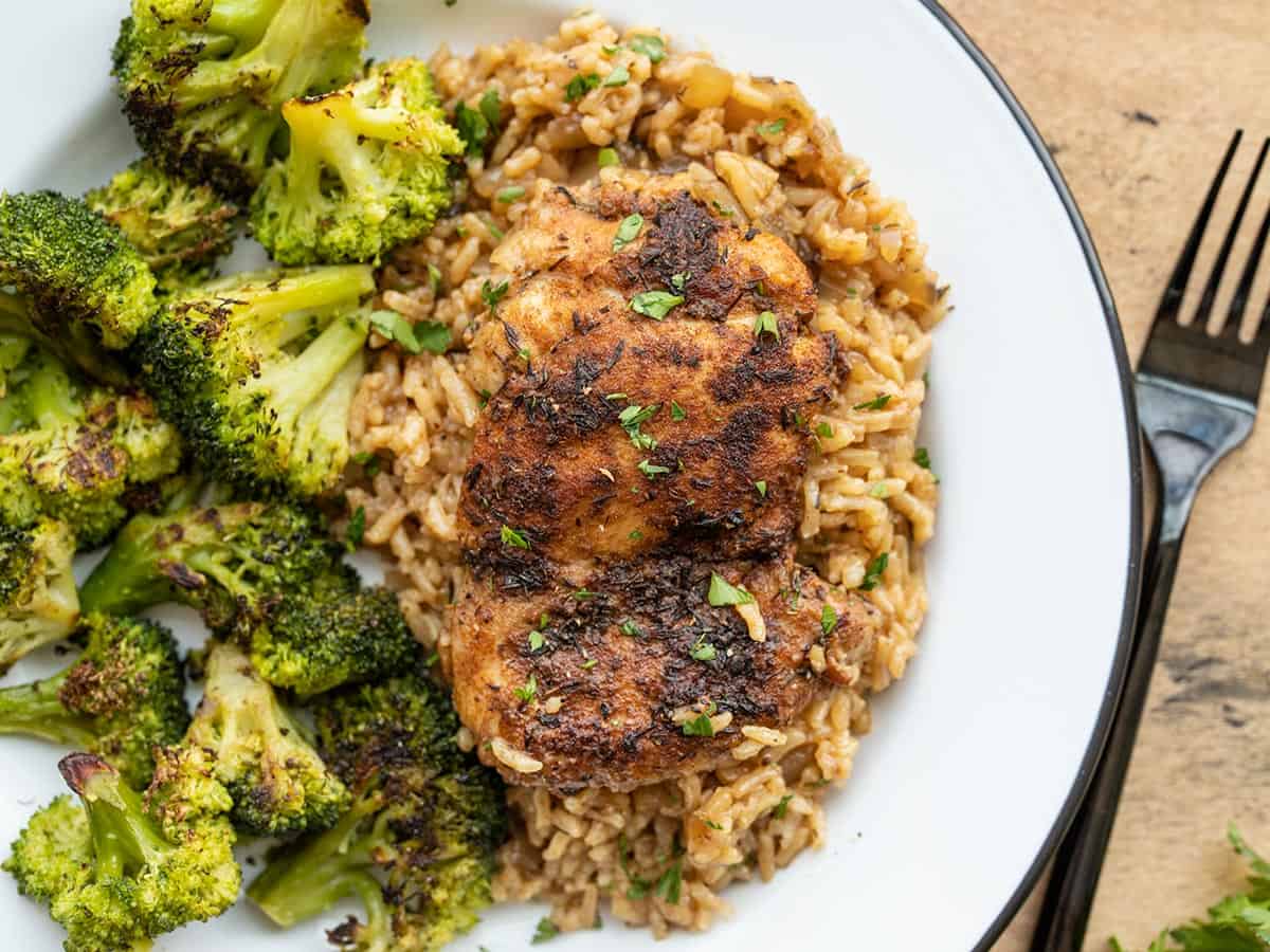 Poulet et riz sur une assiette avec du brocoli rôti.