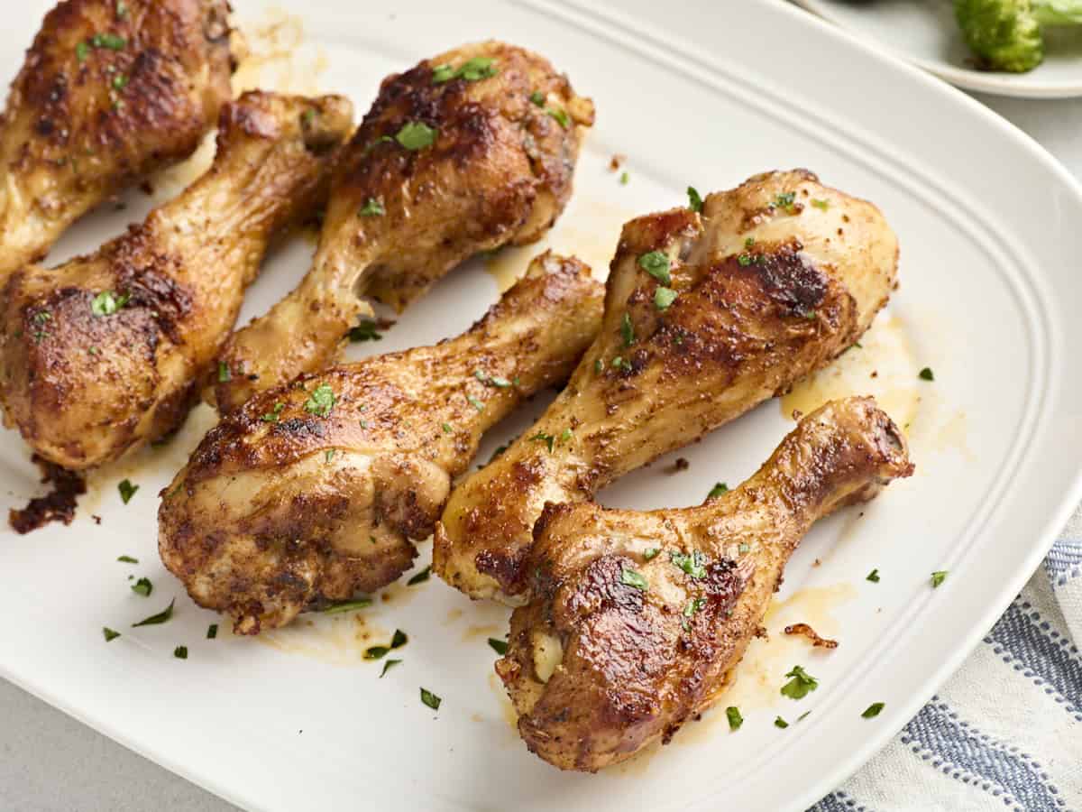 Gros plan de pilons de poulet cuits au four sur une assiette.