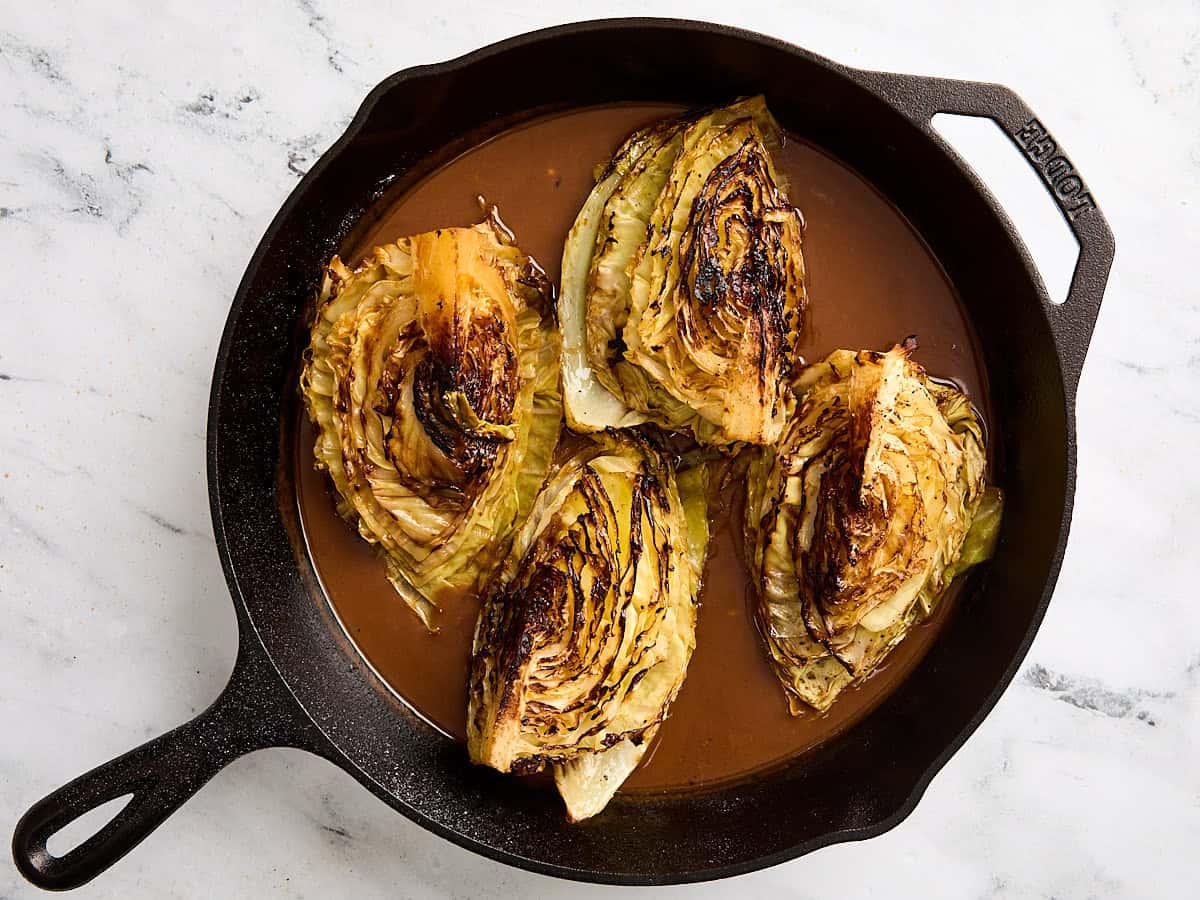 Steaks de chou avec sauce dans une poêle en fonte.