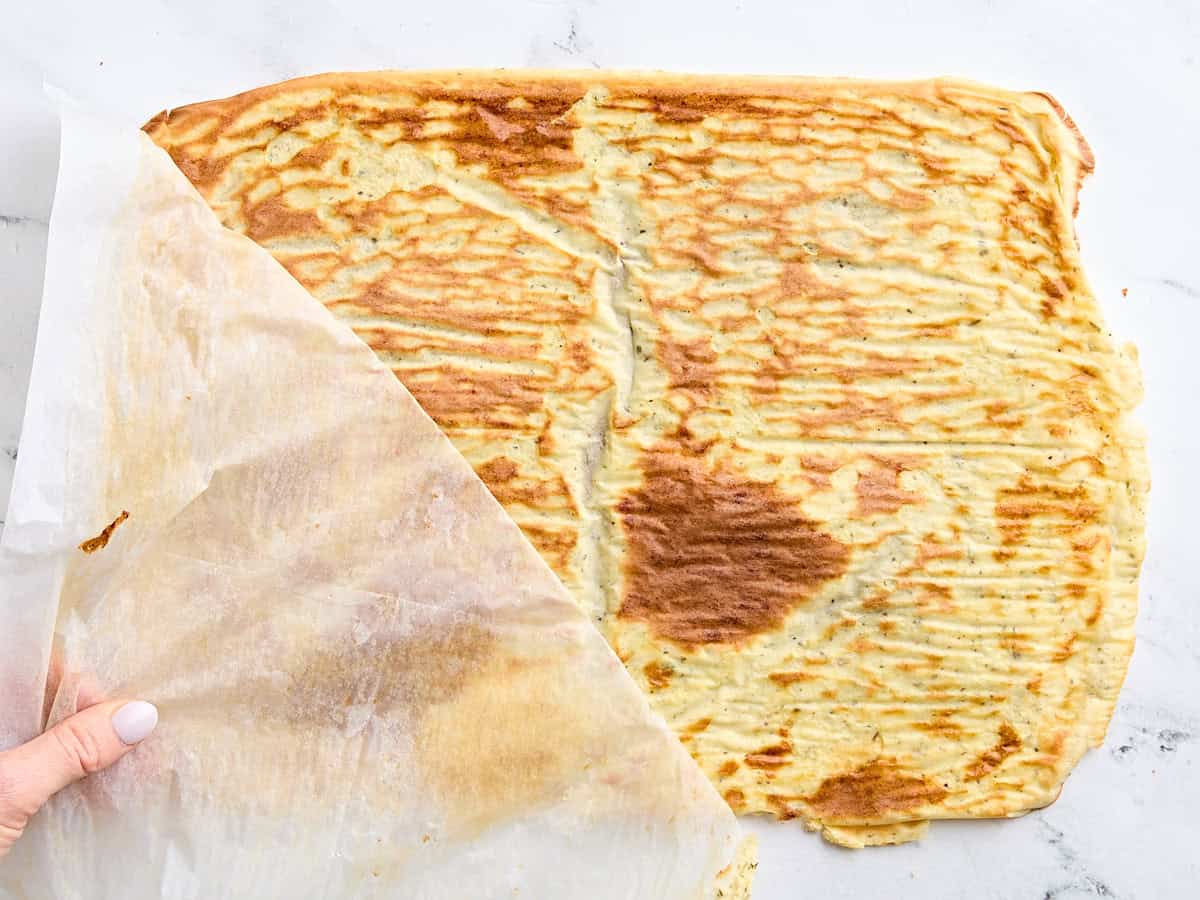 Le papier parchemin est retiré d'un mélange de chalet au four refroidi et d'oeufs.