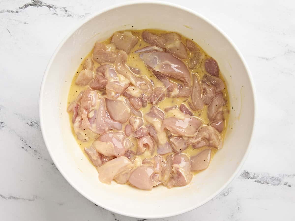 Poulet en dés poulet dans une fécule de maïs et un mélange d'oeufs dans un bol à mélanger.