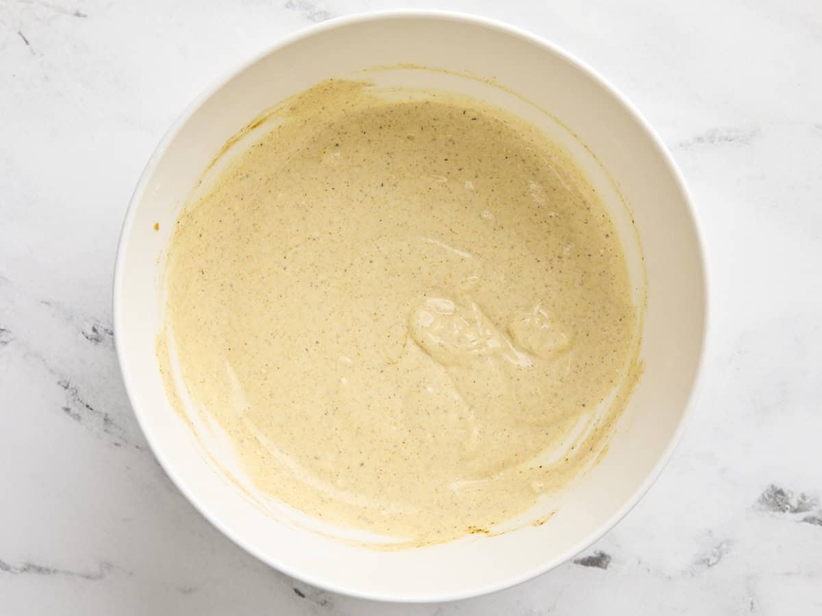 Vêtue de salade de poulet au curry dans un bol à mélanger.