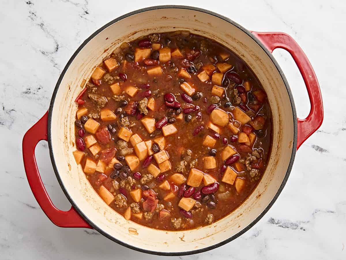 Chorizo ​​Chilli de patates douces dans un pot avant de mijoter.