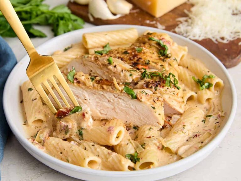 Side view of marry me chicken with a serving of rigatoni pasta.