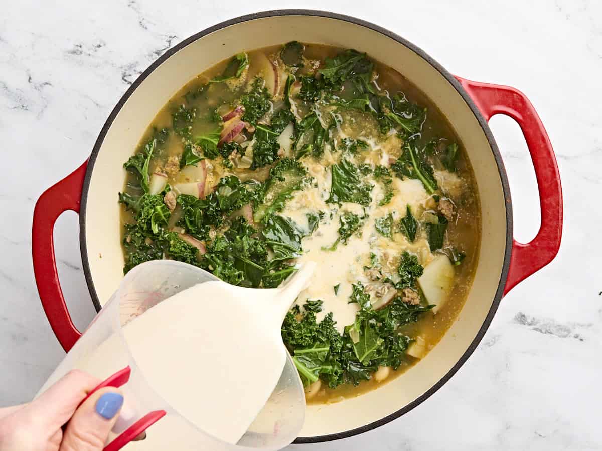 Un mélange de mi-temps et de bouillon de poulet trempé versé dans un pot de Zuppa Toscana.