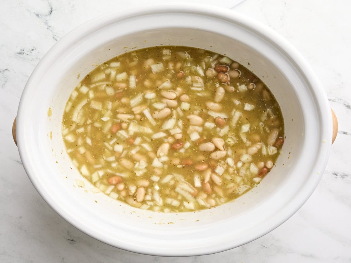 Chili à poulet blanc à la mijoteuse dans une mijoteuse avant la cuisson.