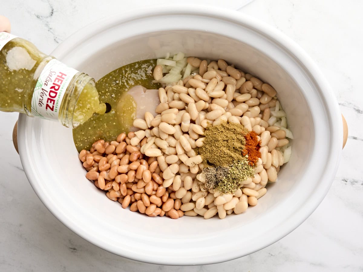 Les haricots en conserve, la salsa verde et les assaisonnements ont ajouté à la mijoteuse.