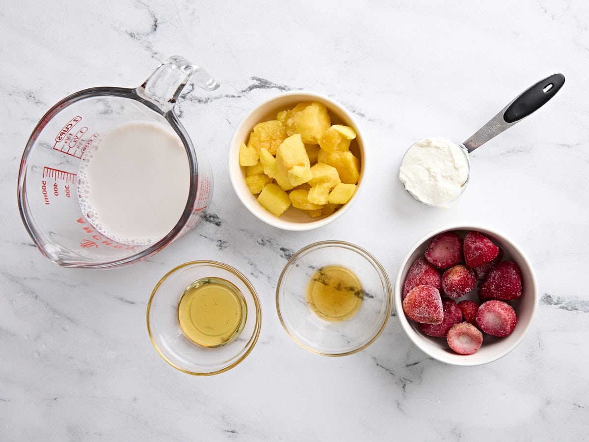 Les ingrédients pour faire un smoothie à la mangue aux fraises.