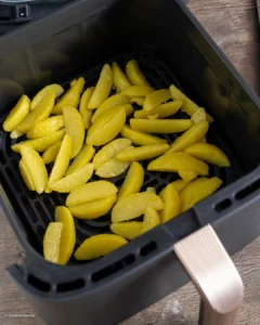 Cuire les coins de pommes de terre dans la friteuse à air chaud.
