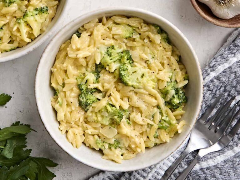 Overhead view of homemade broccoli cheddar orzo in a bowl.