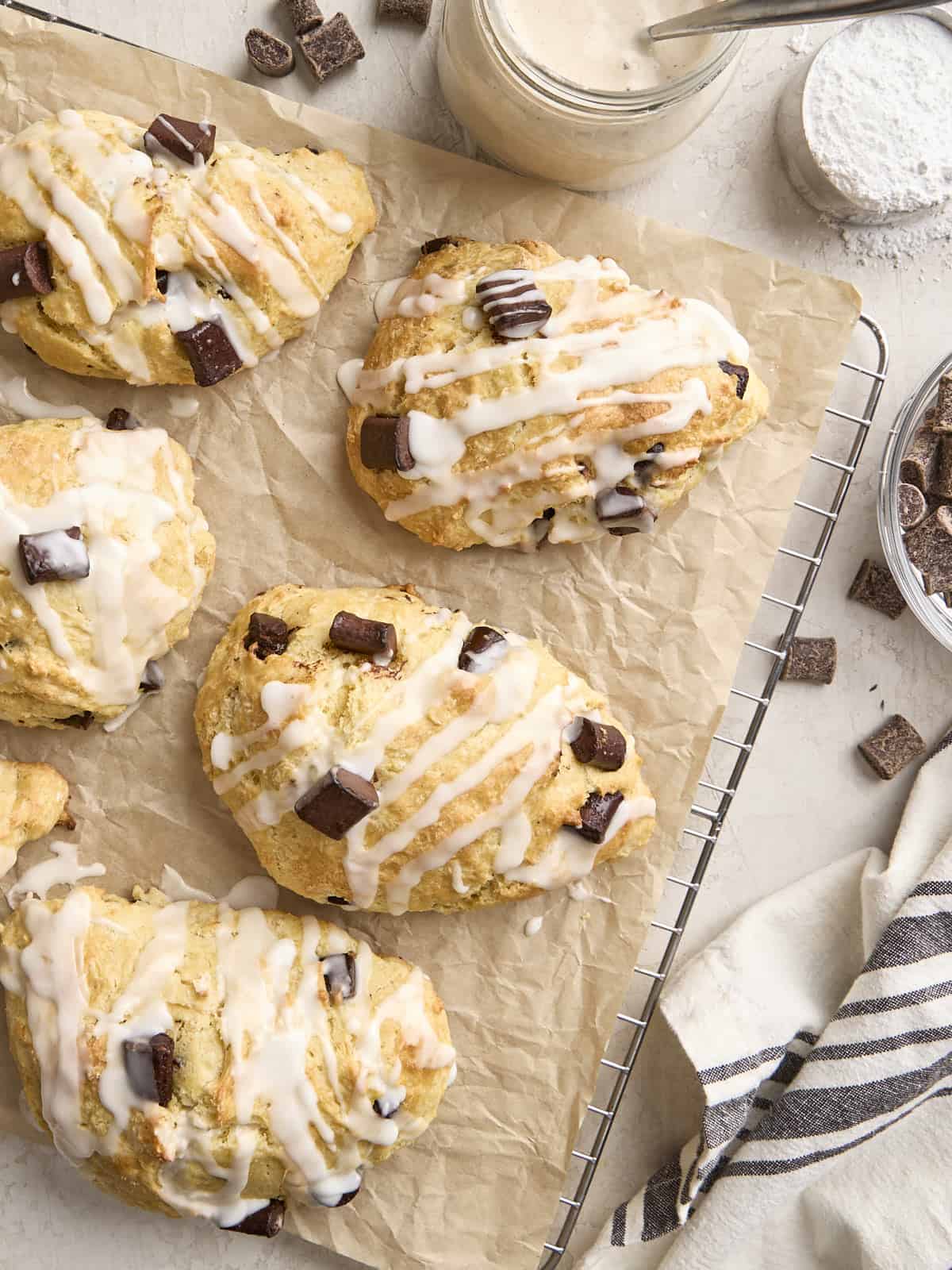 Vue aérienne des scones au levain aux pépites de chocolat maison sur une grille doublée de parchemin.