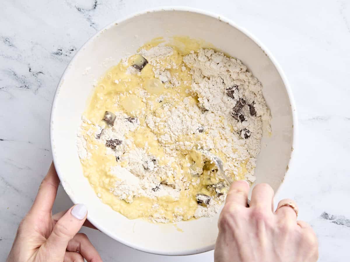 Les ingrédients humides et secs pour les scones de pépites de chocolat au levain sont combinés dans un bol.