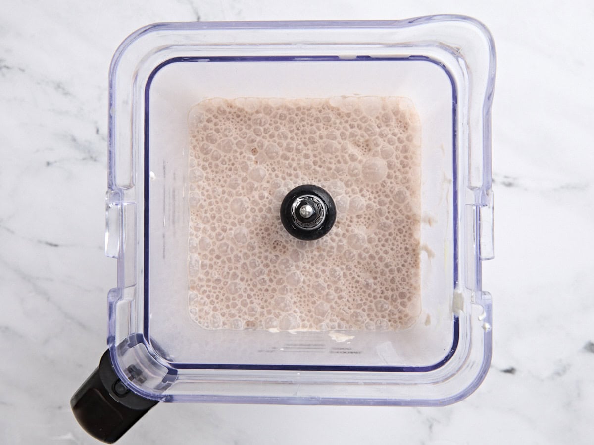 Lait au chocolat, fouet frais et lait condensé sucré dans un mélangeur.