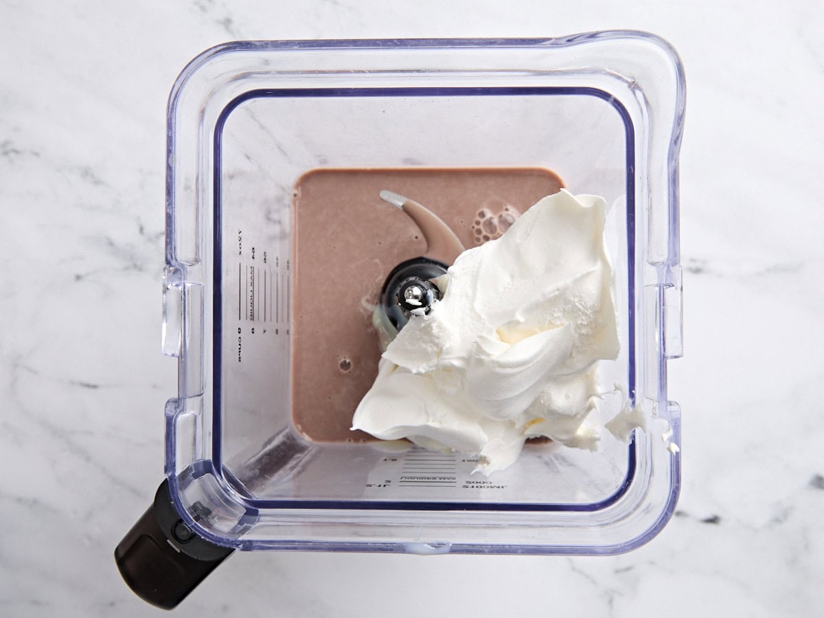 Lait au chocolat, fouet frais et lait condensé sucré dans un mélangeur après avoir été mélangé.