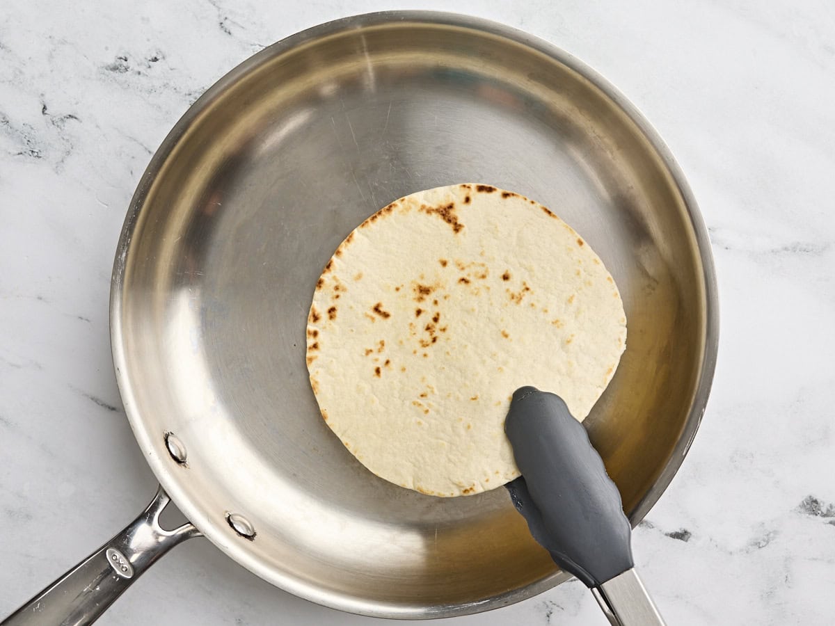 Une tortilla étant grillée dans une poêle.