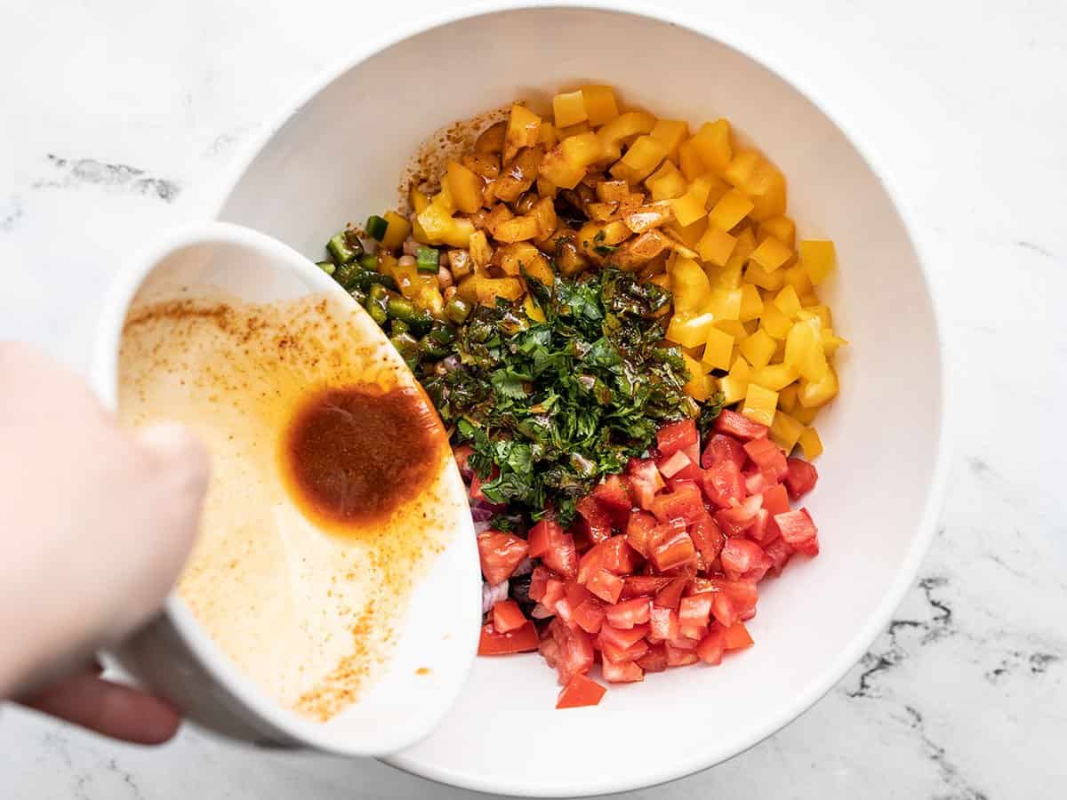 La vinaigrette versée sur la salade dans le bol.