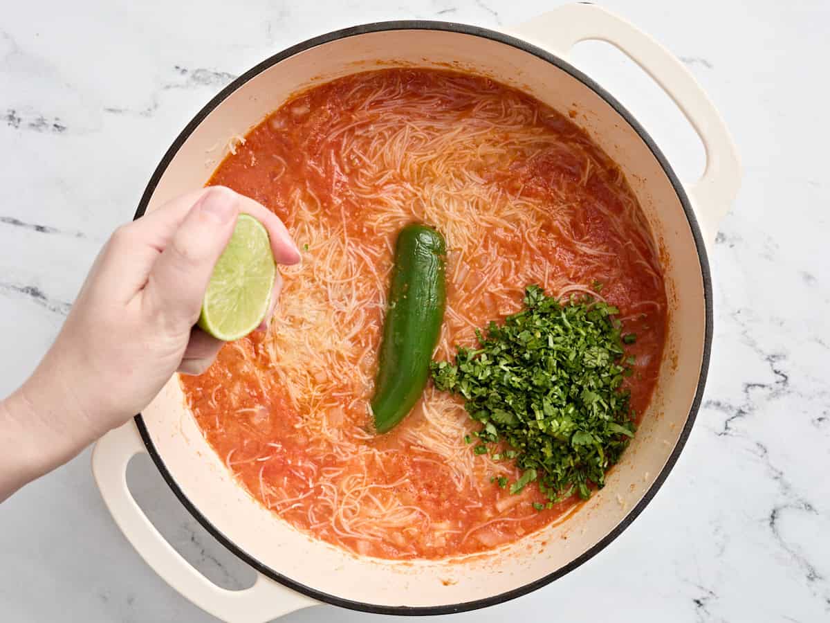 La coriandre hachée et un demi-chaux serrées dans un pot de sopa de fideo.