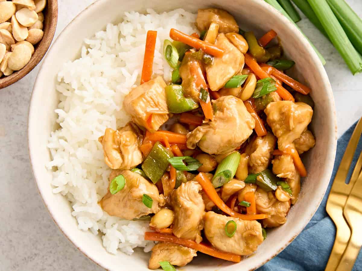 Au-dessus de gros plan de poulet Kung Pao fait maison dans un bol avec du riz cuit.