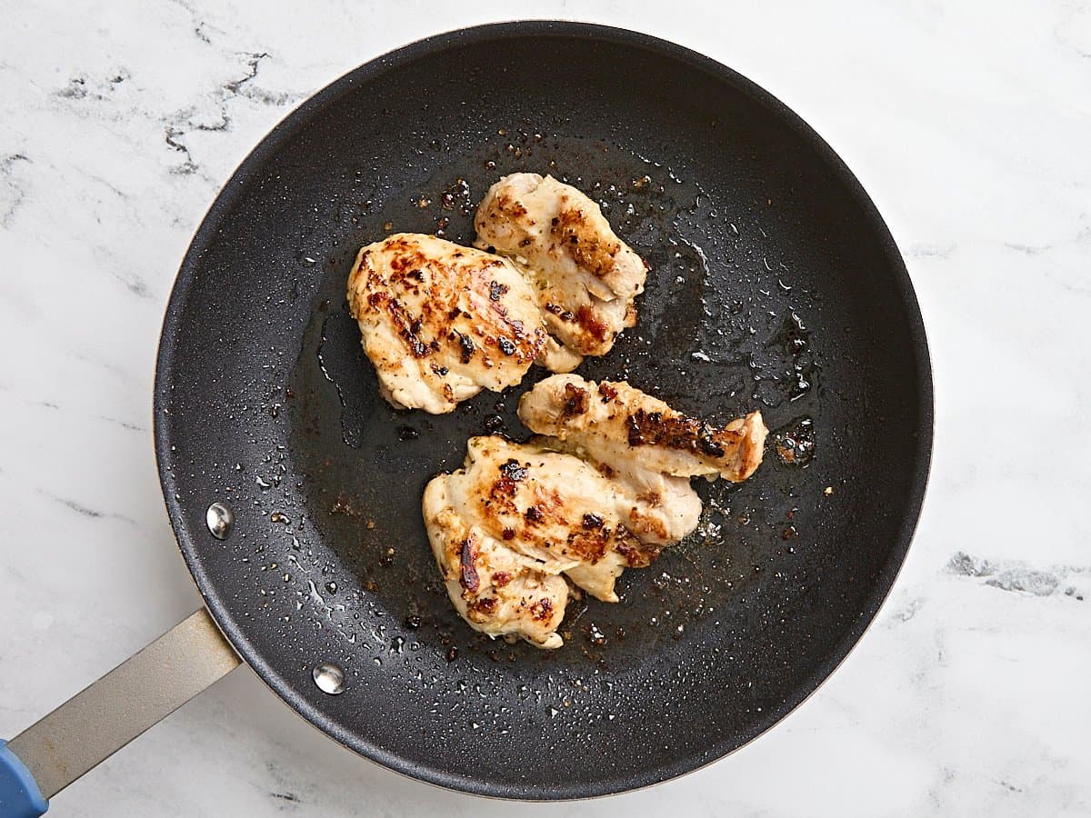 Cuisses de poulet cuisinées dans une poêle.