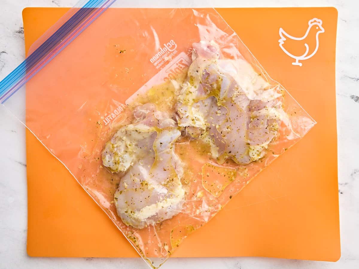 Cuisses de poulet dans un sac ziplock avec marinade de citron.