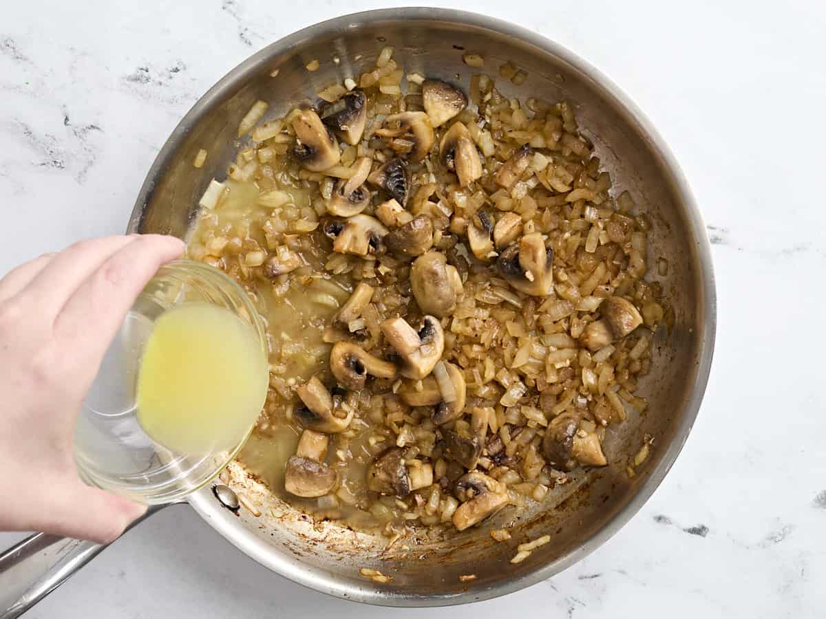 Le bouillon de poulet ajouté aux champignons et à l'oignon sautés.