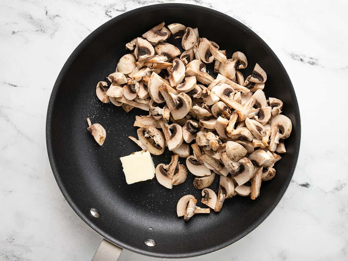 Champignons tranchés dans une poêle avec beurre.