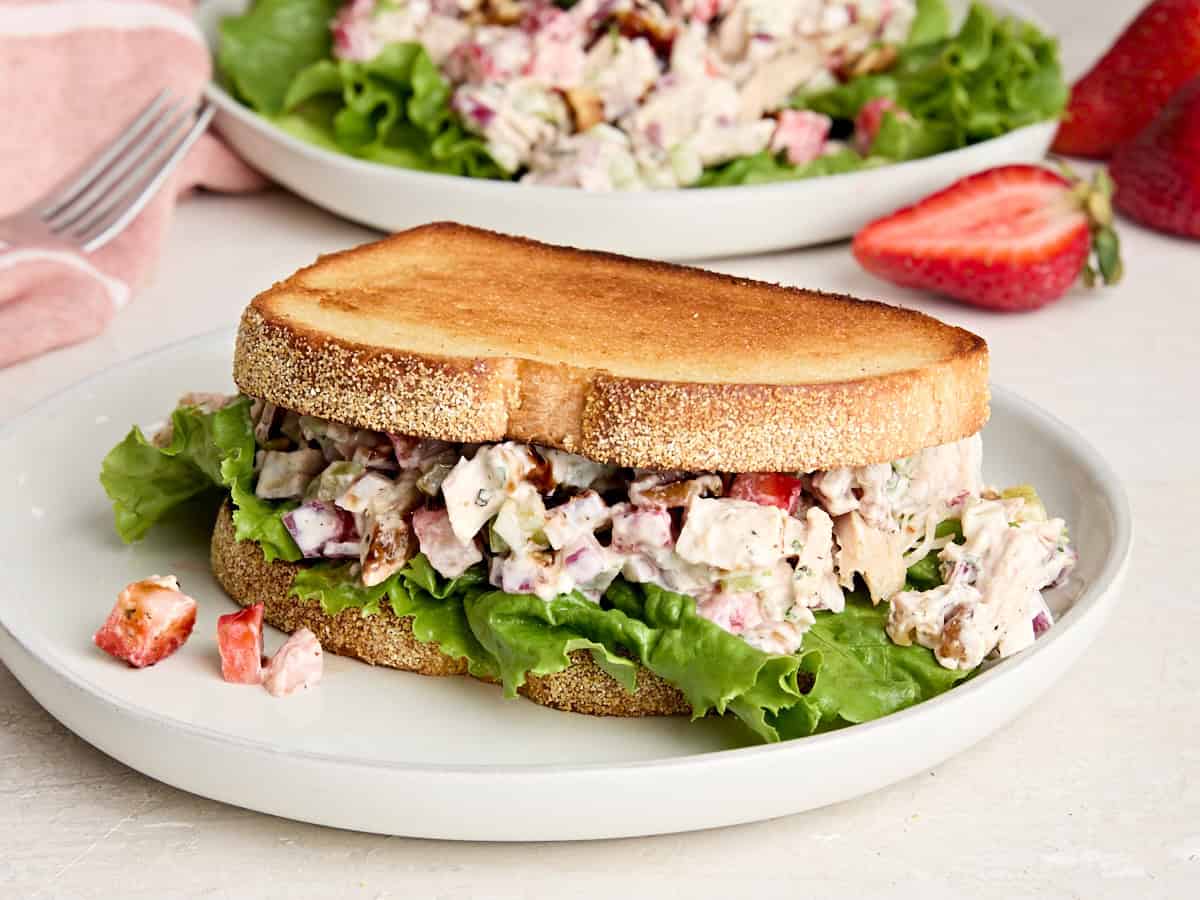 Un sandwich à la salade de poulet aux fraises dans une assiette.