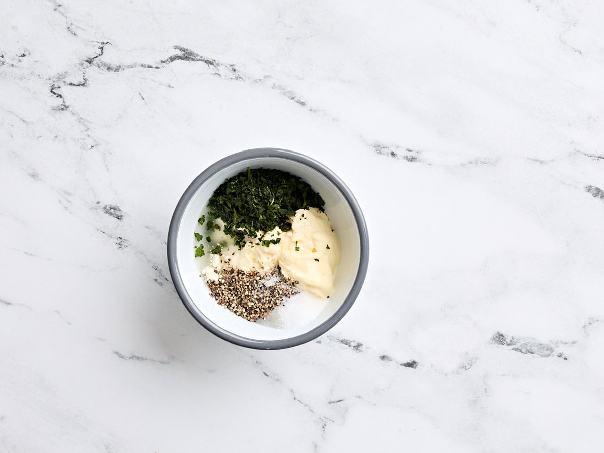 Mayonnaise, basilic, vinaigre blanc, sel et poivre dans un petit bol à mélanger.