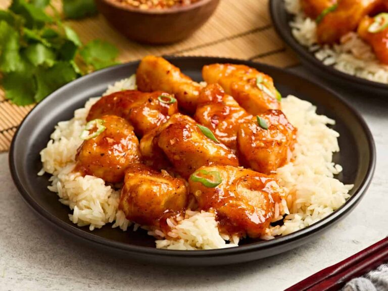 Side view of firecracker chicken on a bed of rice.