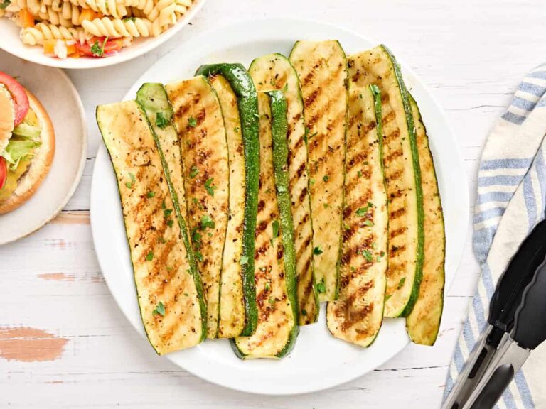 Overhead view of grilled zucchini slices on a plate.