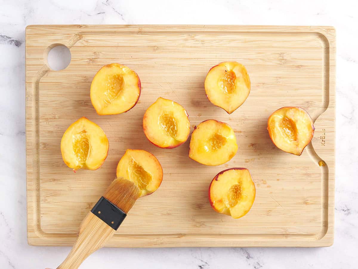 Les moitiés de pêche sont brossées d'huile.