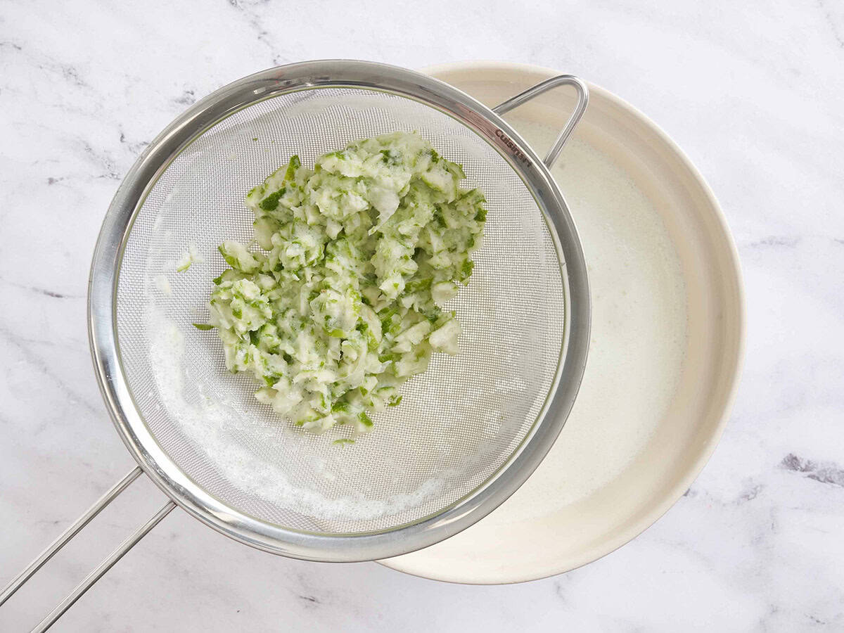 Pipe de citron vert dans une passoire sur un bol de limonade brésilienne maison.