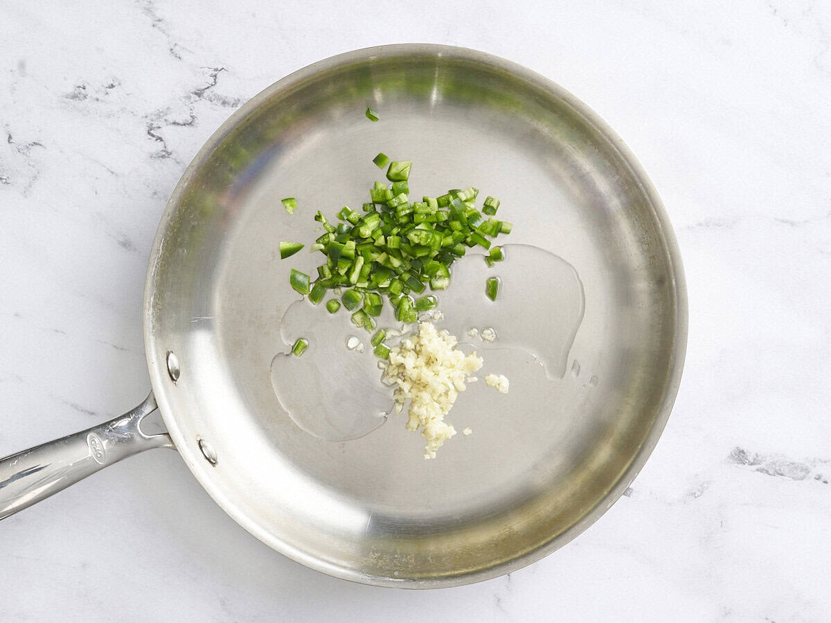 Jalapeno en dés et ail dans une poêle.