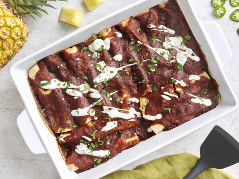 Overhead view of beef enchiladas in a baking dish.