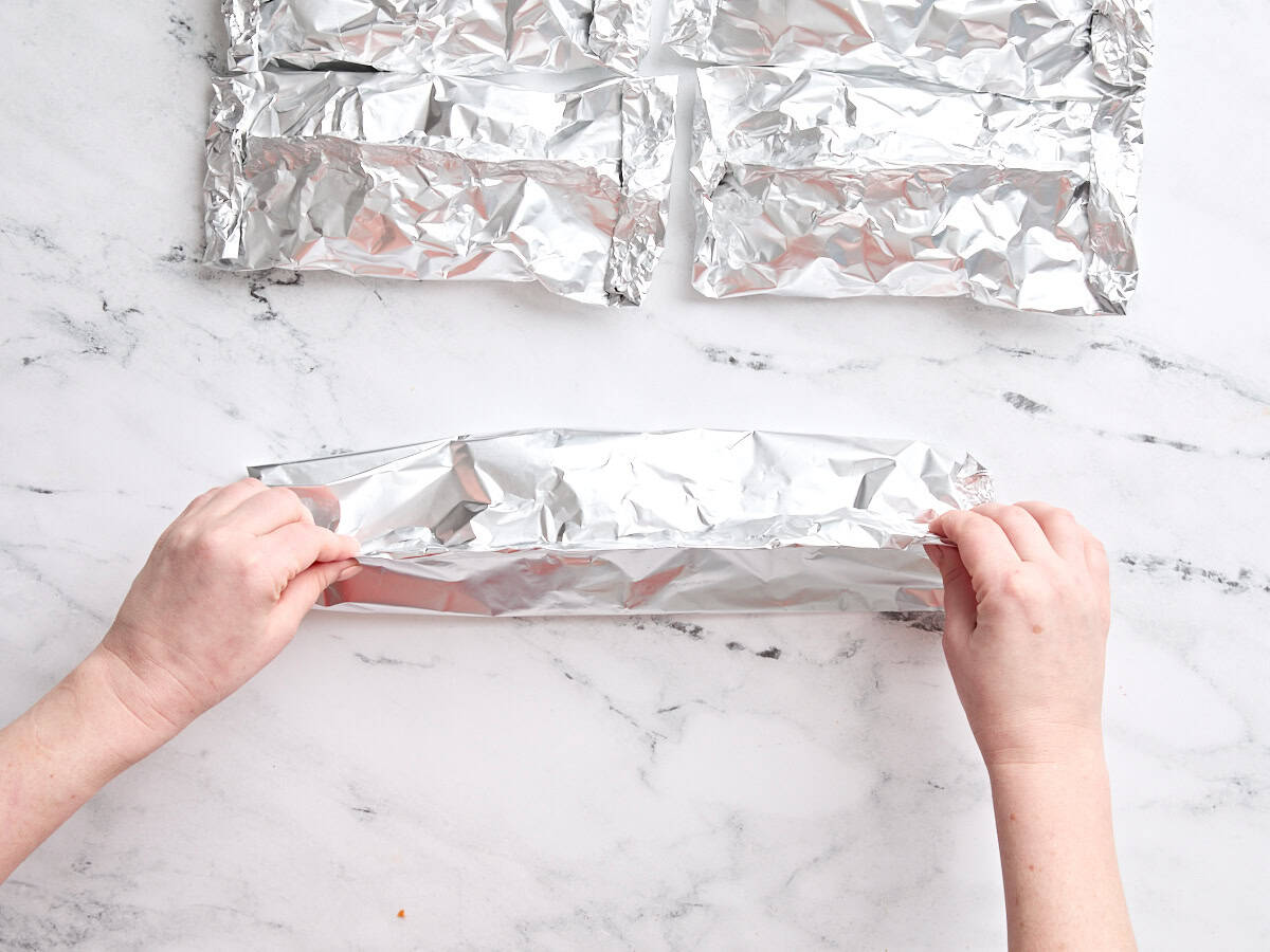 Mains pliant un paquet de feuille de crevettes.