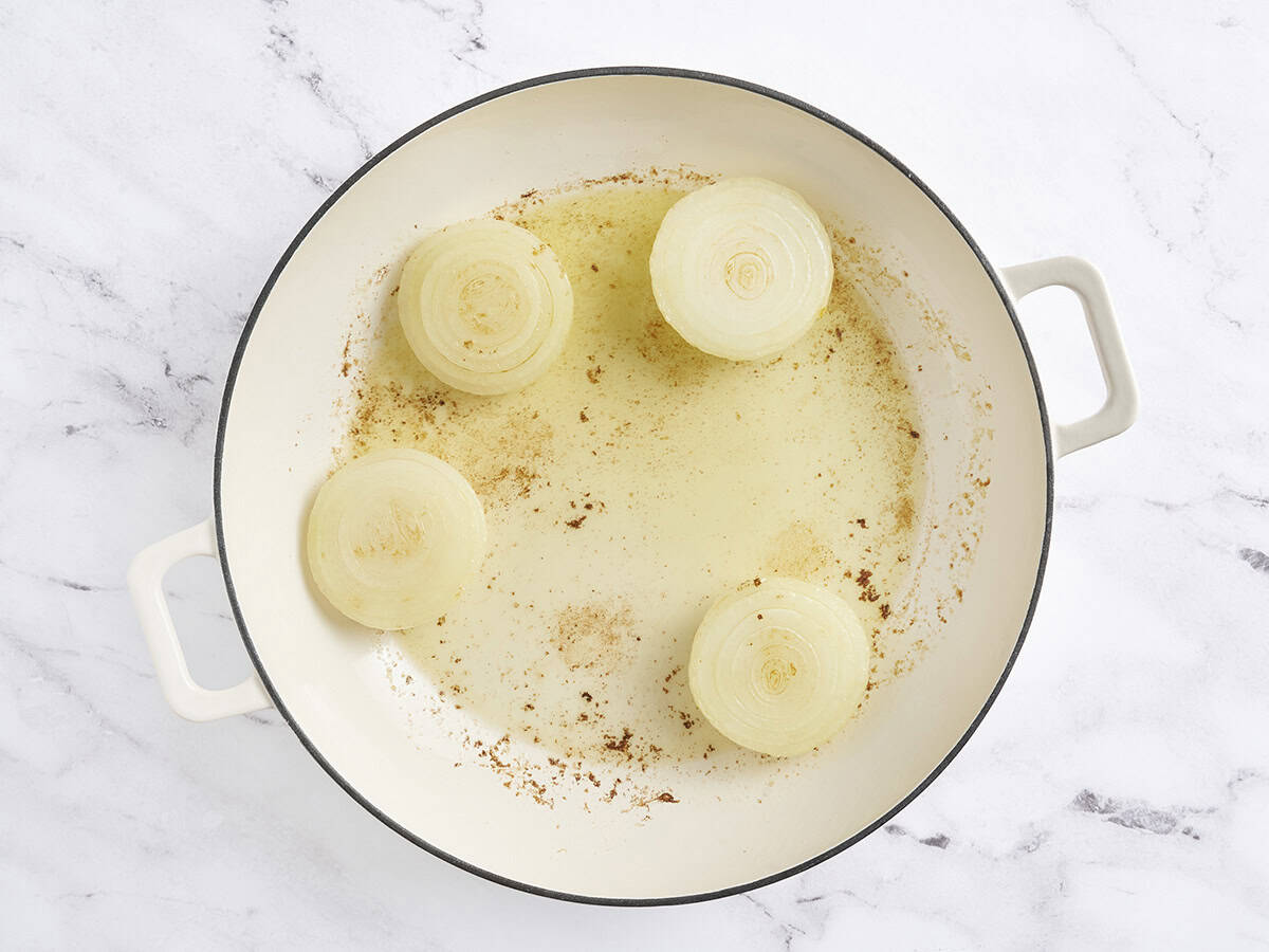 L'oignon des moitiés brunissant dans une poêle.