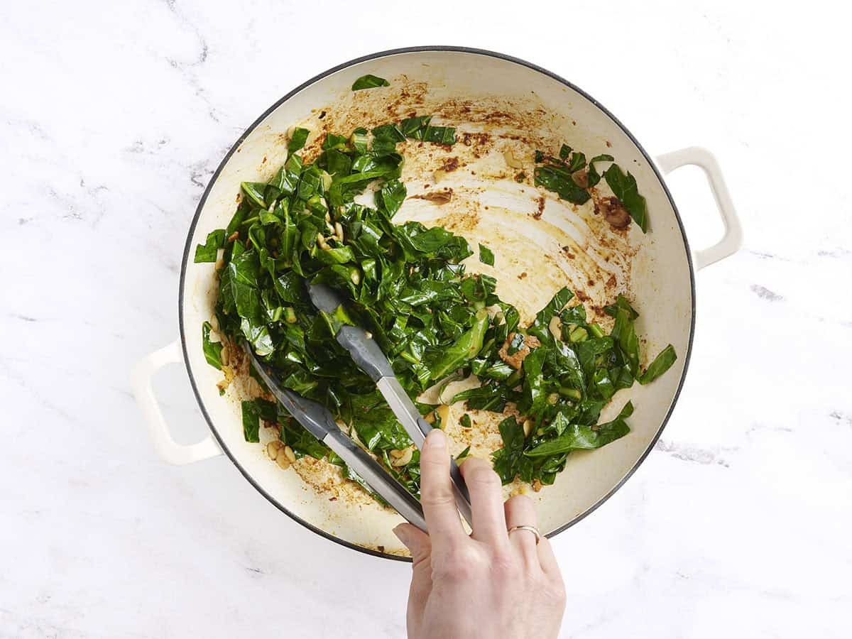 Greens cuites avec de l'ail dans une poêle.