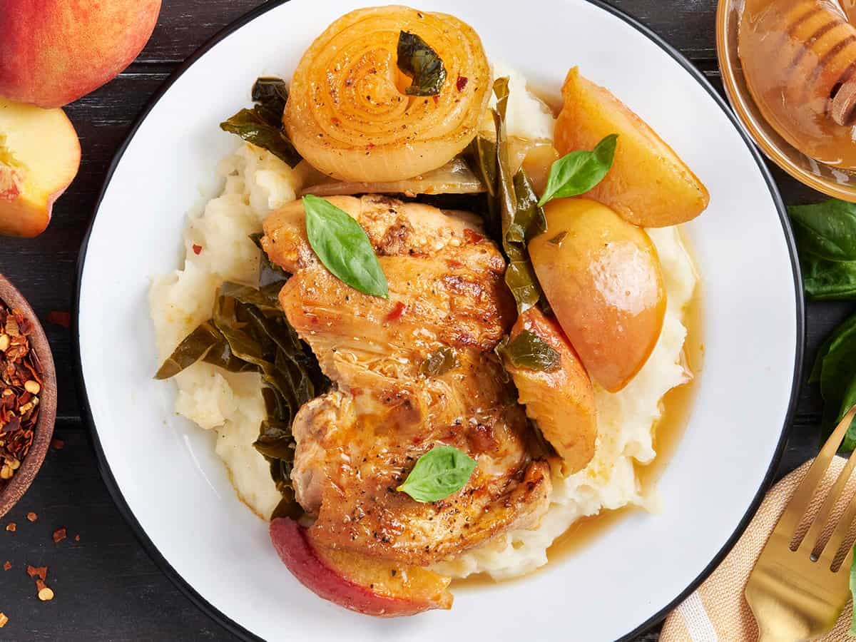 Poulet de pêche dans une assiette avec purée de pommes de terre et légumes.