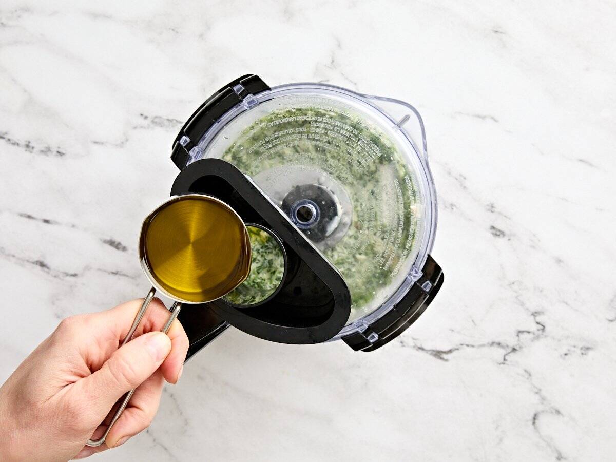 L'huile est diffusée dans un robot culinaire pour fabriquer une vinaigrette à salade de déesse verte.