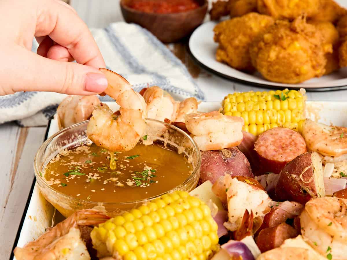 Un morceau de crevettes trempé dans du beurre assaisonné.