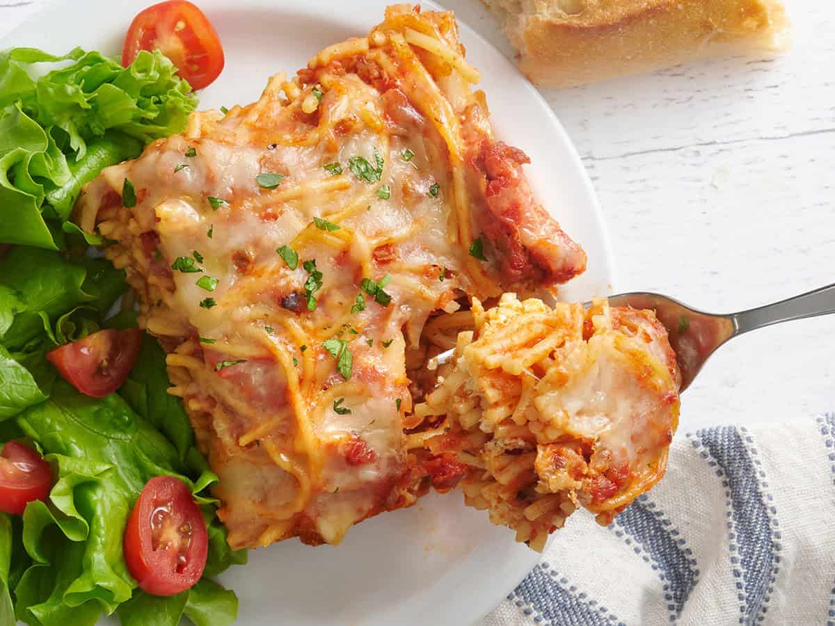 Un morceau de spaghetti cuit dans une assiette avec une fourchette en prenant.