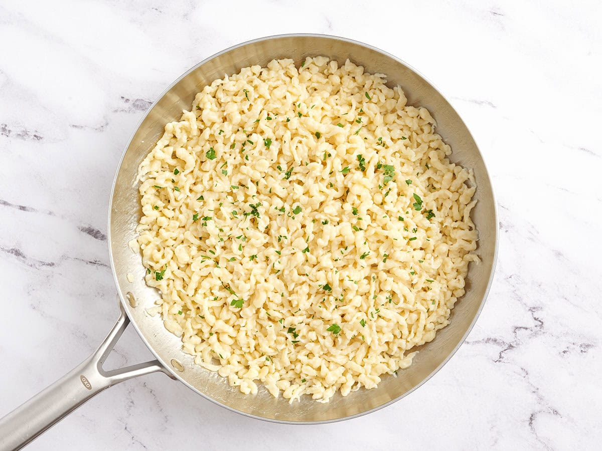 Spaetzle dans une poêle avec du beurre fondu et du persil.