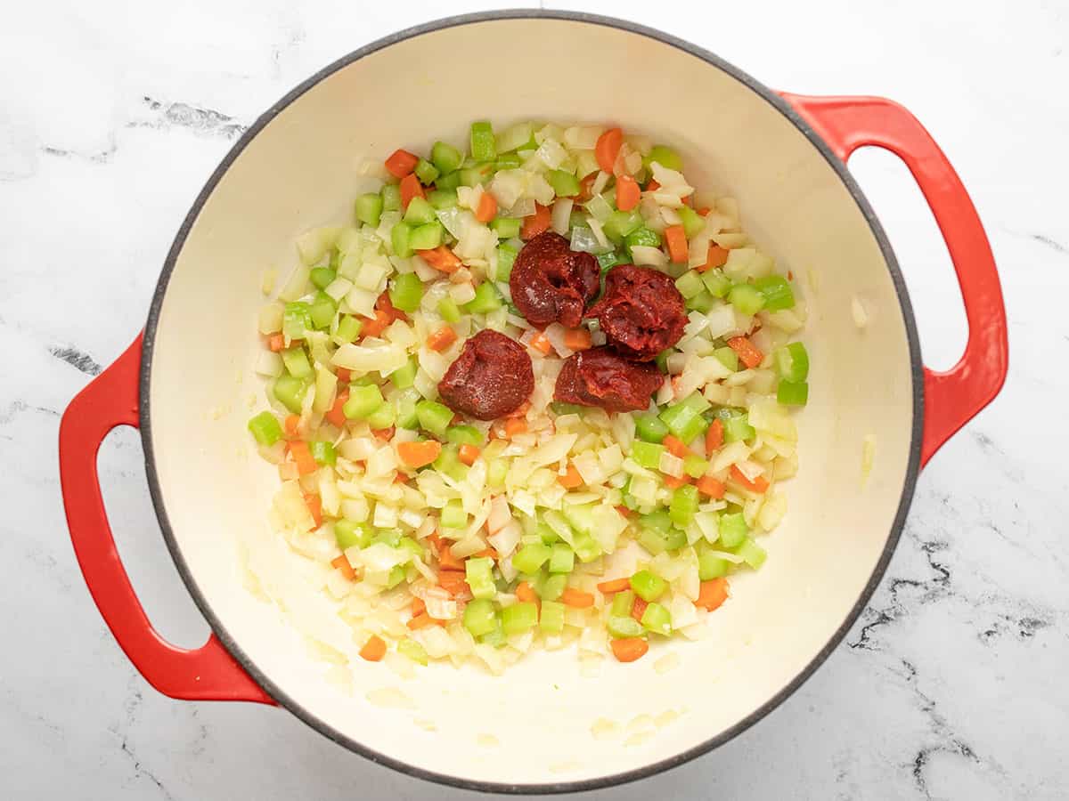 La pâte de tomate ajoutée au pot à soupe.
