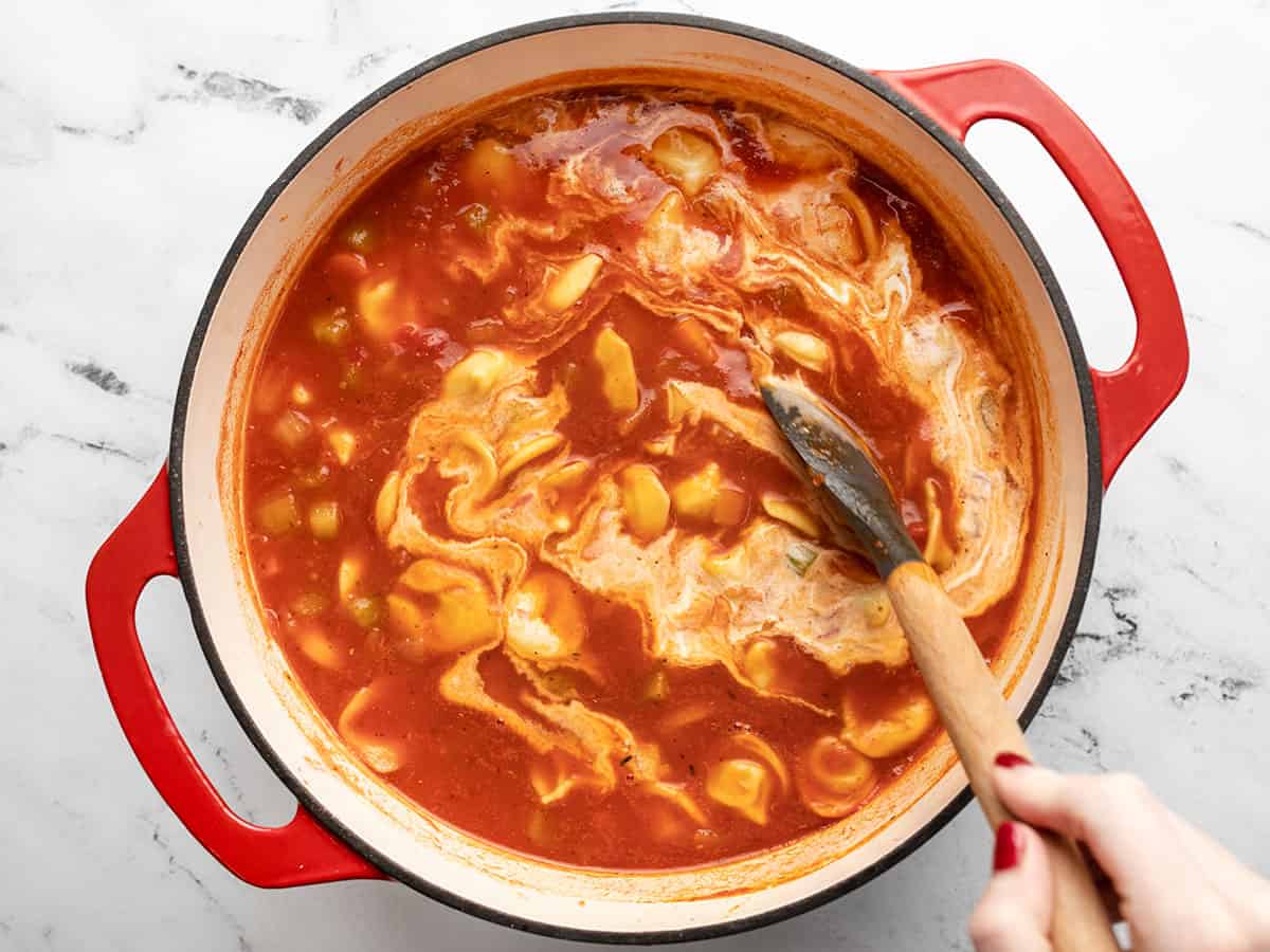 La crème épaisse étant remuée dans la soupe. 