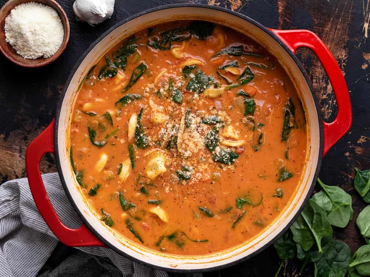 Vue aérienne du pot fini de soupe crémeuse des tortellini garnies de parmesan et de poivre. 