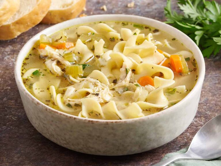 Side view of a bowl of chicken noodle soup.
