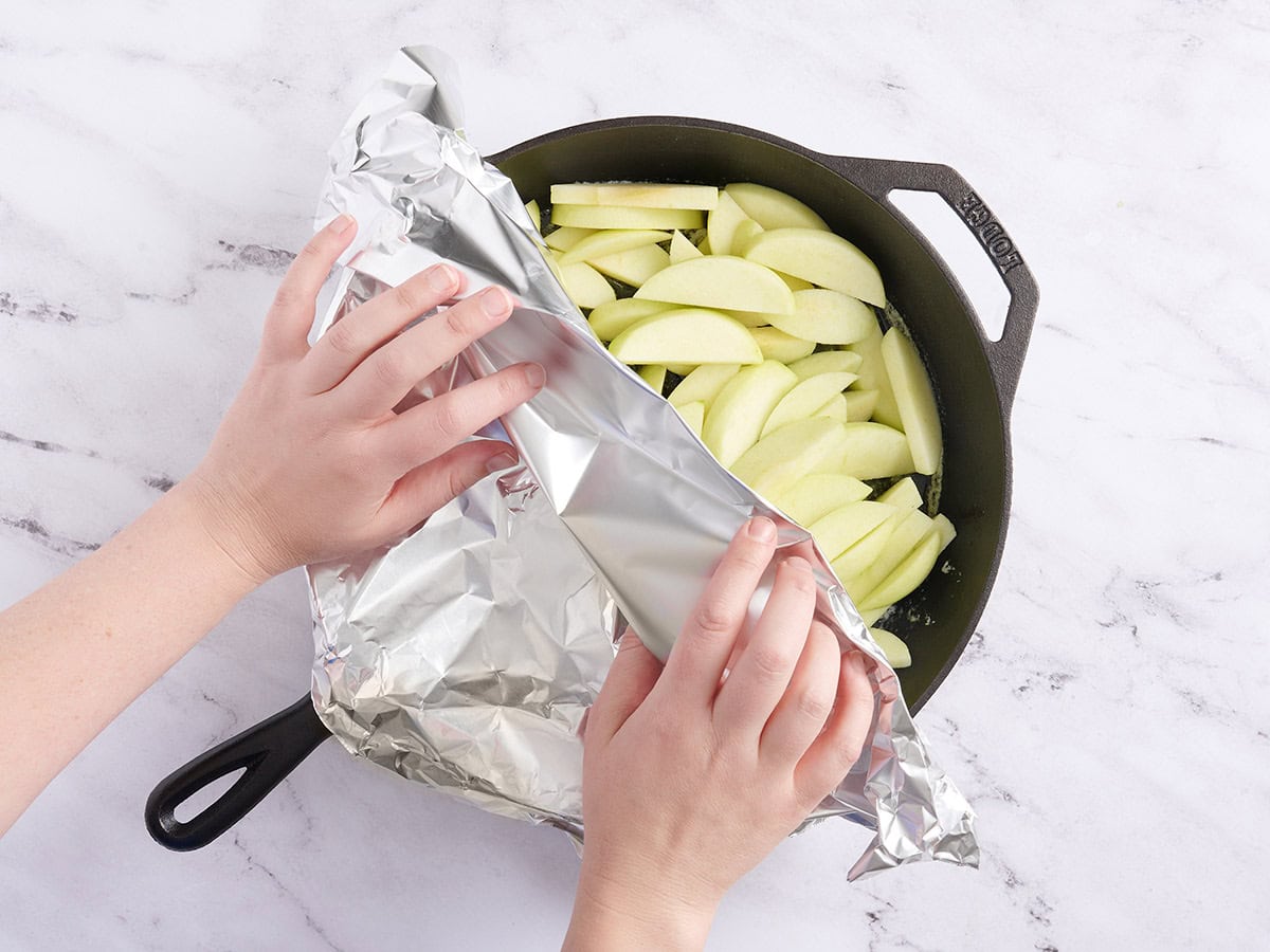 Une poêle en fonte recouverte de papier d'aluminium.