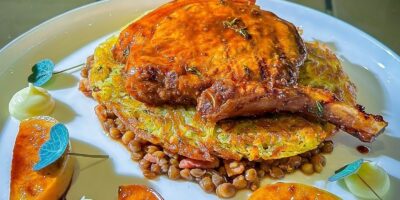 Chop de porc glacée grillée de Neven avec rosti, pommes caramélisées et lentilles balsamiques